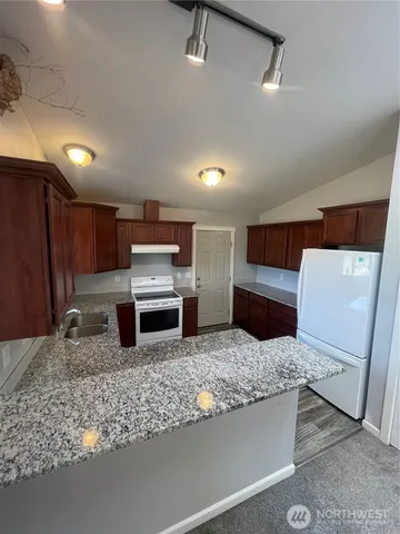 a kitchen with sink refrigerator and stove