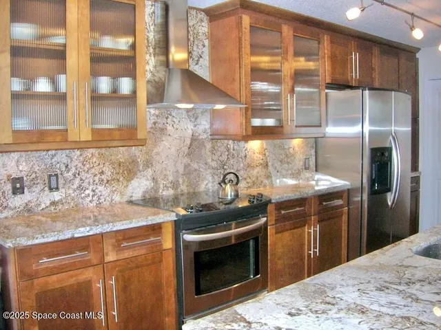a kitchen with stainless steel appliances granite countertop a sink stove and refrigerator