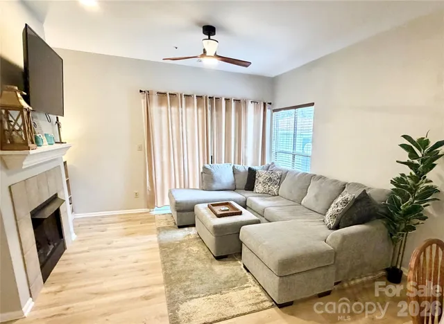 a living room with furniture a flat screen tv and a fireplace