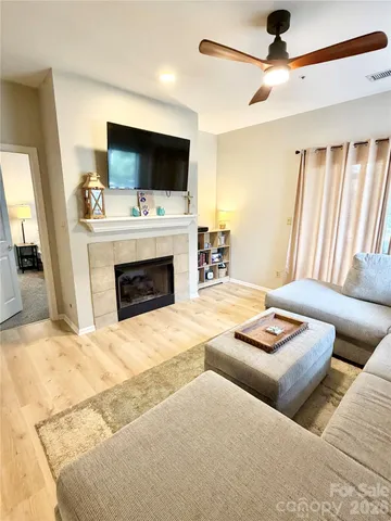 a living room with furniture a fireplace and a flat screen tv