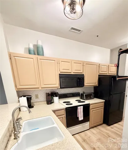 a kitchen with a sink appliances and cabinets