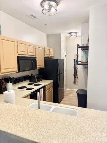 a kitchen with a refrigerator and a stove top oven
