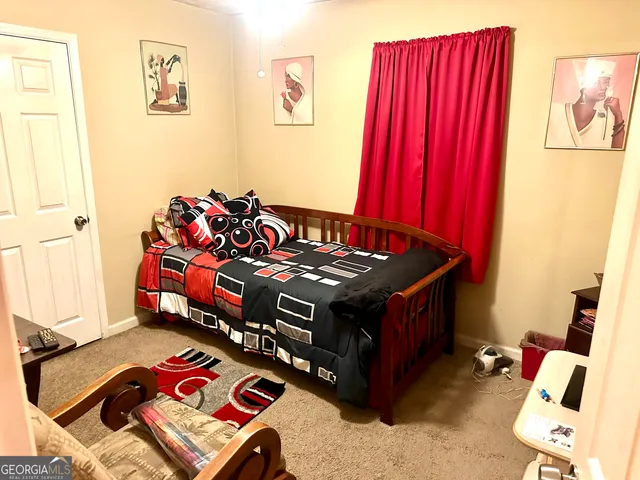 a bed sitting in a bedroom next to a window