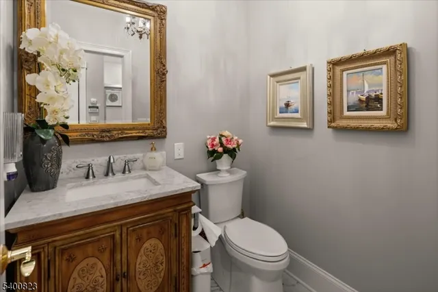 a bathroom with a sink vanity mirror and toilet