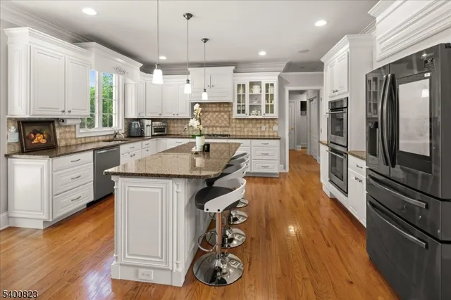 a kitchen with granite countertop a sink appliances counter top space and cabinets