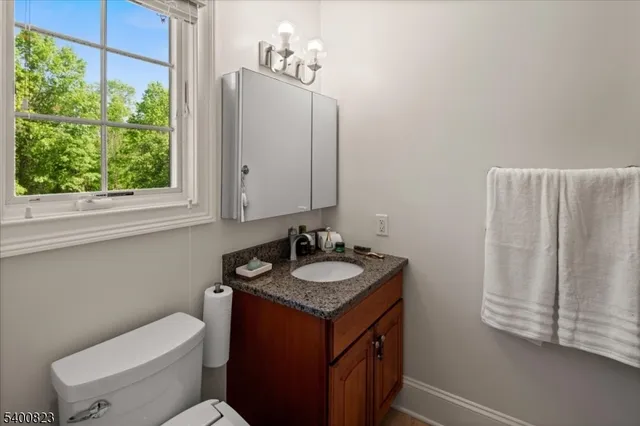 a bathroom with a granite countertop toilet sink and mirror