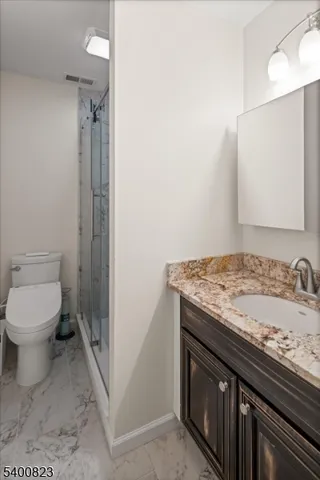 a bathroom with a granite countertop sink toilet and shower