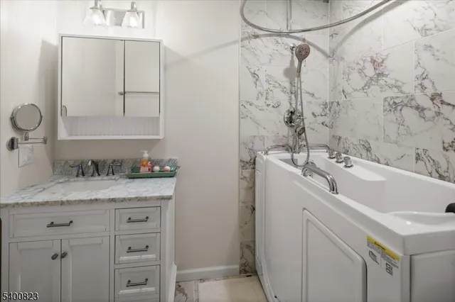 a bathroom with a sink and a mirror with bathtub