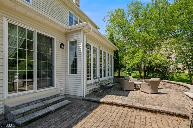 a backyard of a house with potted plants and large tree