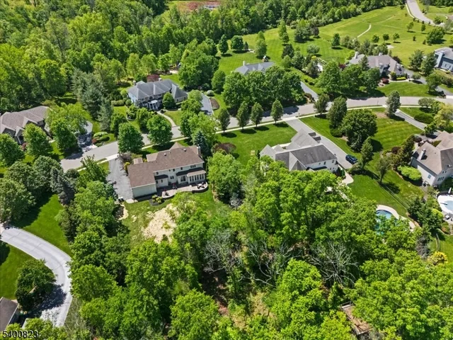 an aerial view of residential house with outdoor space and trees all around