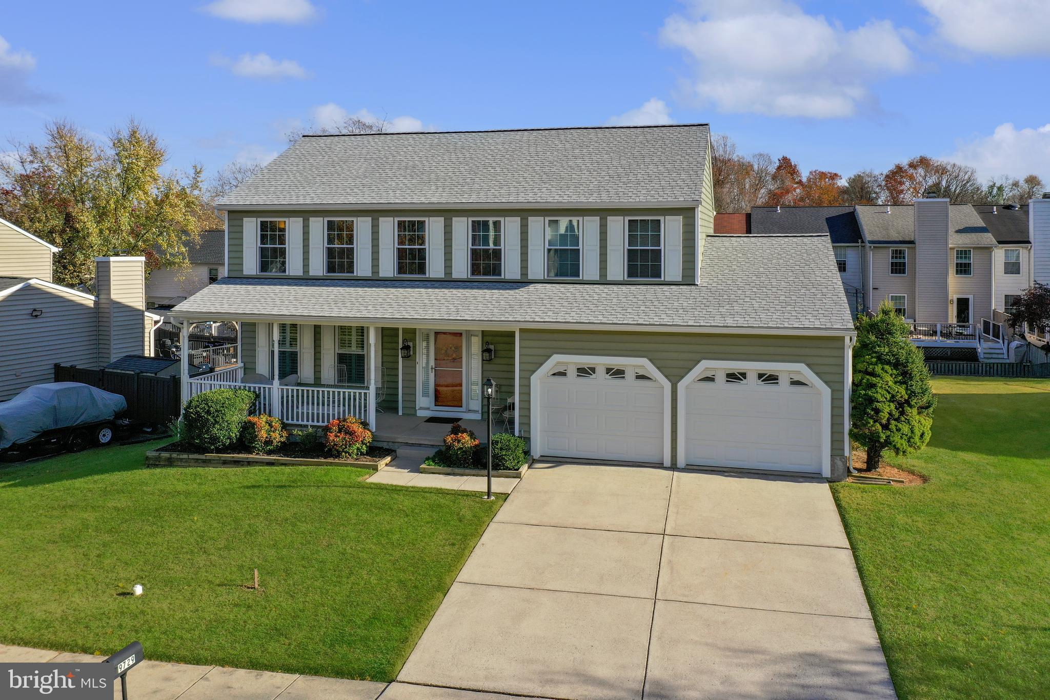 a front view of a house with a garden and trees