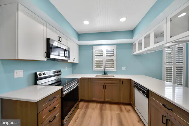 a kitchen with granite countertop a sink cabinets and wooden floor
