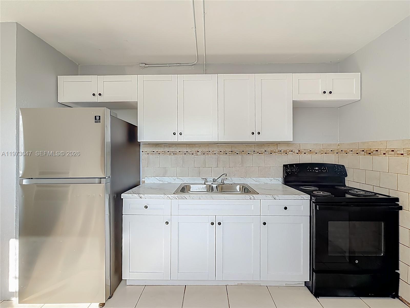 2408 Northwest 8th Street Pompano Beach, FL 33069 - Photo 1 of 24 a kitchen with a sink a stove and refrigerator