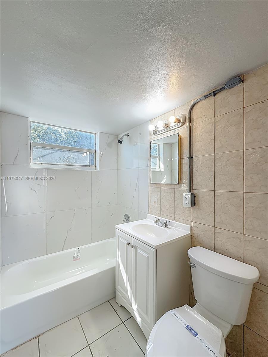 2408 Northwest 8th Street Pompano Beach, FL 33069 - Photo 17 of 24 a bathroom with a toilet a sink and bathtub