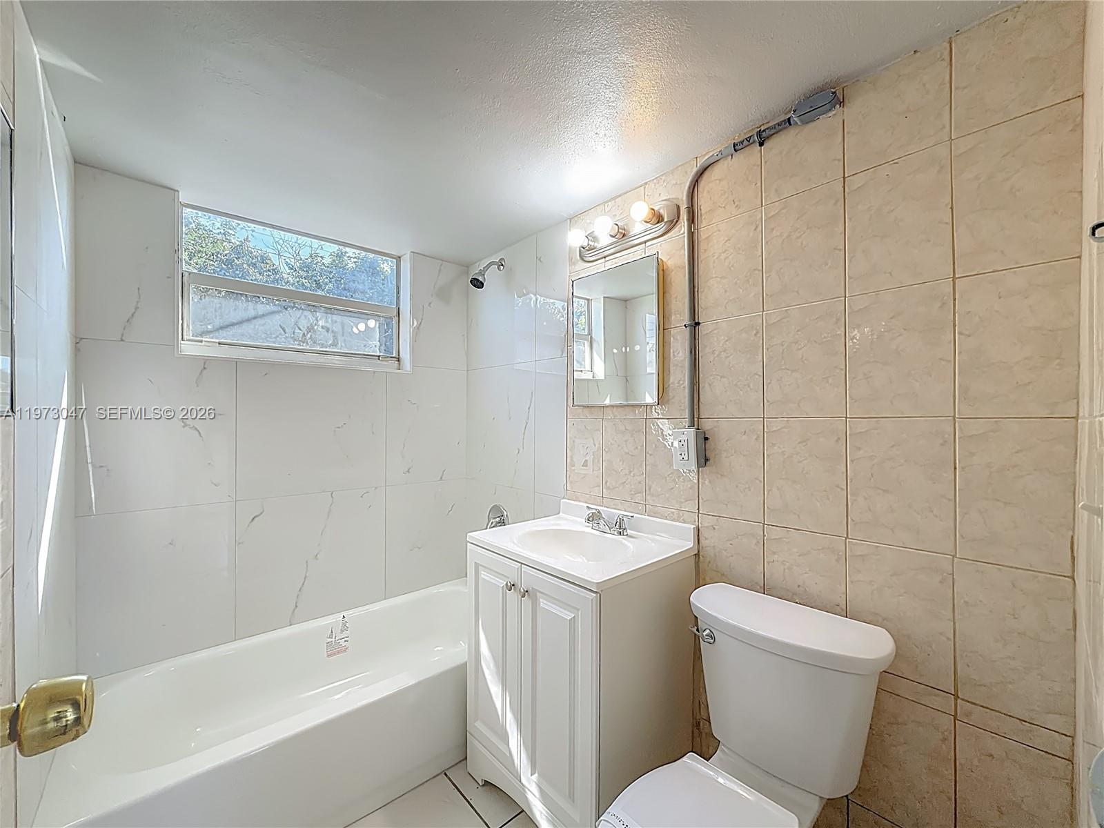 2408 Northwest 8th Street Pompano Beach, FL 33069 - Photo 18 of 24 a white toilet sitting next to a bath tub