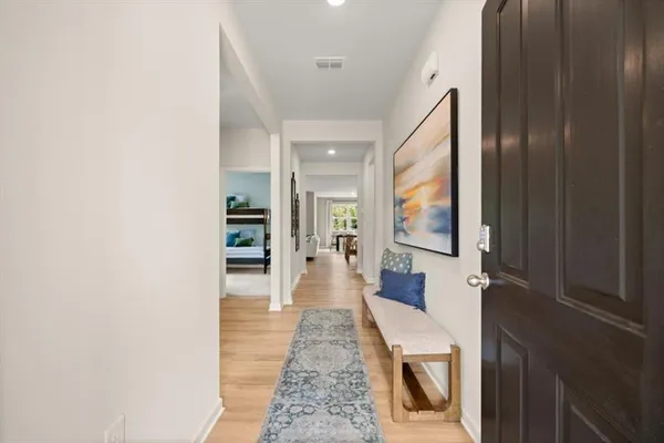 a view of a hallway with wooden floor and furniture