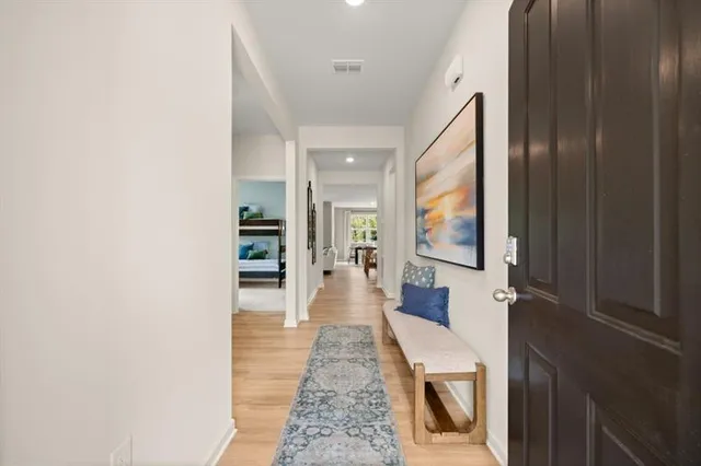 a view of a hallway with wooden floor and furniture