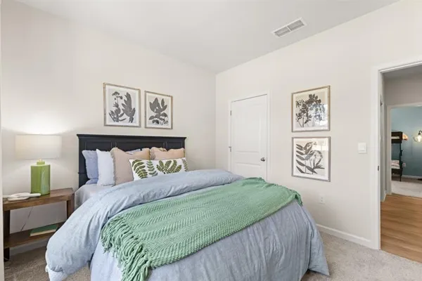 a bedroom with a bed and a dresser with mirror