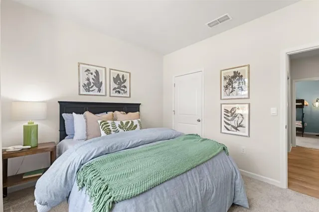 a bedroom with a bed and a dresser with mirror