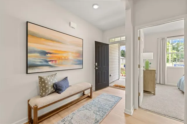 a view of a hallway with a dining room with wooden floor and electronic appliances
