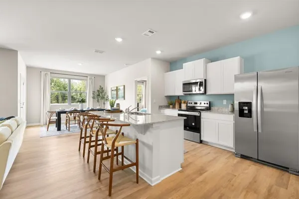 a kitchen with stainless steel appliances granite countertop a dining table and chairs