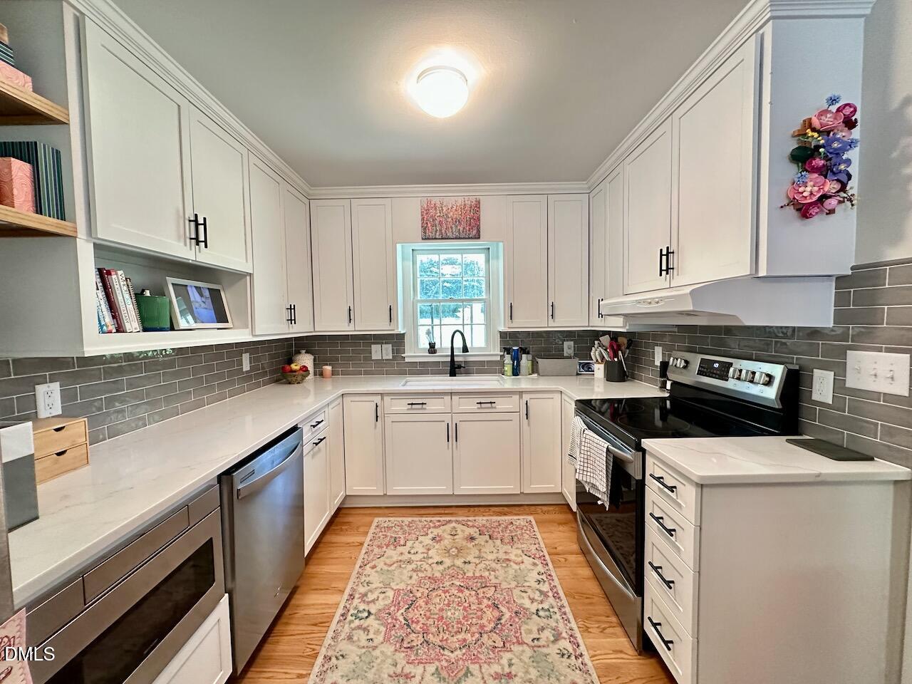 2813 Barmettler Street Raleigh, NC 27607 - Photo 8 of 22 a kitchen with a white cabinets stove top oven and sink