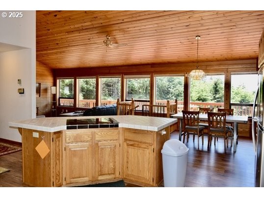 34518 Mutts Way Gold Beach, OR 97444 - Photo 11 of 40 a kitchen with a stove a refrigerator a dining table and chairs