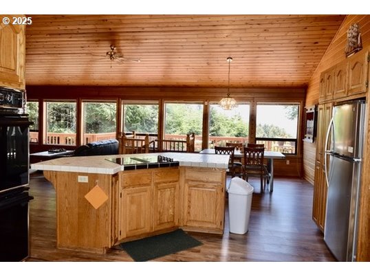 34518 Mutts Way Gold Beach, OR 97444 - Photo 26 of 40 a kitchen with stainless steel appliances a sink a refrigerator a table and chairs