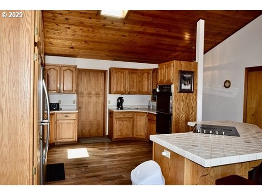 34518 Mutts Way Gold Beach, OR 97444 - Photo 39 of 40 a kitchen with stainless steel appliances kitchen island granite countertop a refrigerator and a stove top oven
