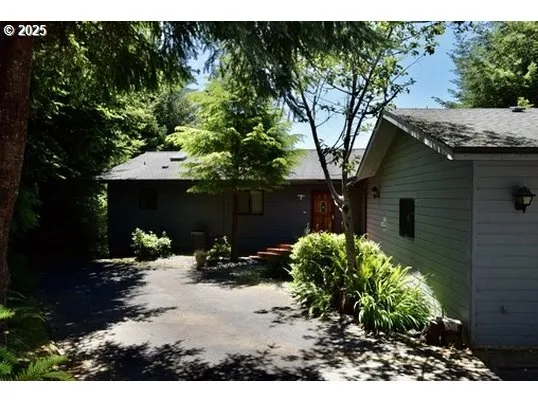 a backyard of a house with table and chairs under an umbrella