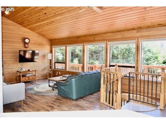 34518 Mutts Way Gold Beach, OR 97444 - Photo 6 of 40 a living room with furniture floor to ceiling window and a flat screen tv