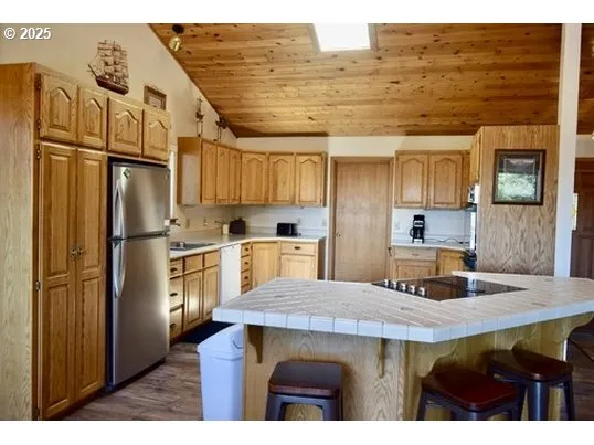 a kitchen with stainless steel appliances granite countertop a refrigerator a stove and a sink