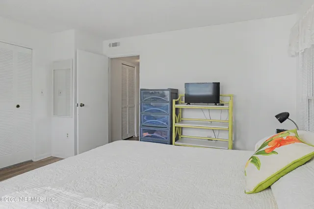 a bedroom with a bed and flat screen tv