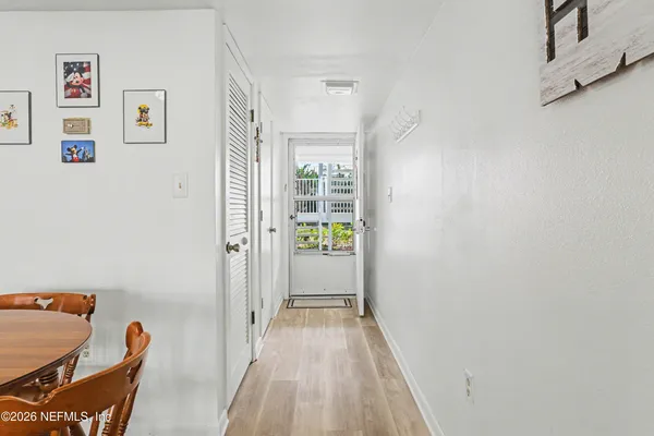 a view of a hallway with furniture and wooden floor
