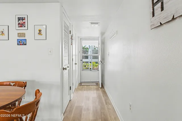 a view of a hallway with furniture and wooden floor