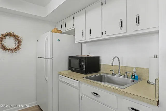 a kitchen with appliances a sink and cabinets