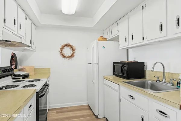 a kitchen with stainless steel appliances granite countertop a sink a stove and a refrigerator