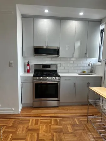 a kitchen with stainless steel appliances granite countertop a stove a sink and a microwave