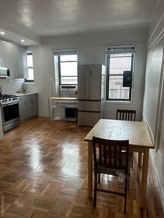 a kitchen with a table chairs sink and cabinets