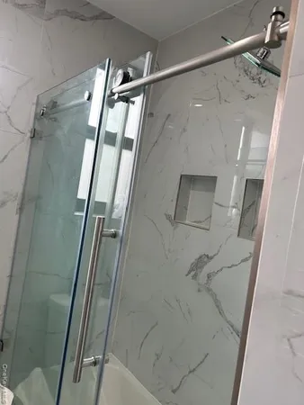 a bathroom with a glass door shower and vanity