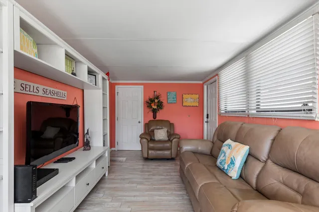 a kitchen with stainless steel appliances granite countertop a stove a sink a dining table and chairs with wooden floor