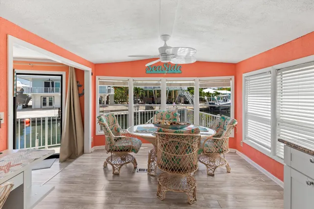 a kitchen with stainless steel appliances kitchen island granite countertop a refrigerator a stove a sink dishwasher and white cabinets with wooden floor