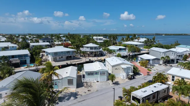 an aerial view of residential houses with outdoor space and parking