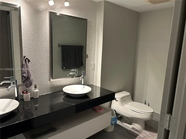 a bathroom with a toilet a sink and mirror