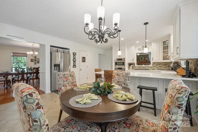 a view of a dining room with furniture and chandelier