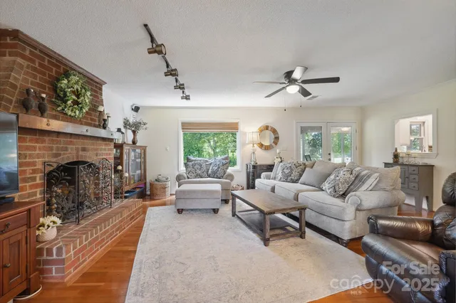 a living room with furniture a fireplace and a large window