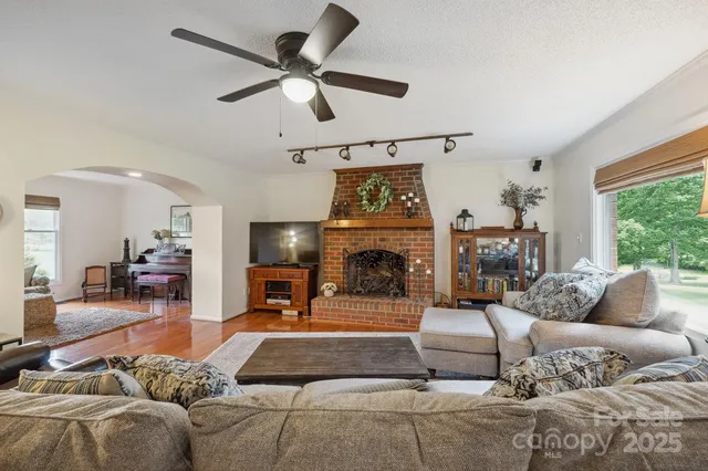 a dining room top with furniture a chandelier a large window and a kitchen view