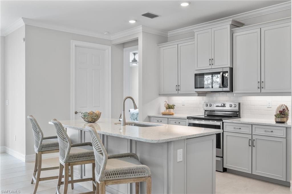 a kitchen with stainless steel appliances granite countertop a white table and chairs