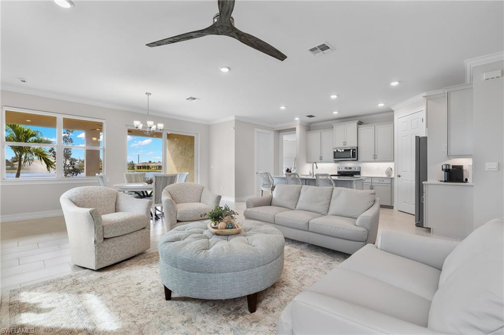 318 Deauville Loop Naples, FL 34114 - Photo 2 of 21 a living room with furniture kitchen view and a chandelier
