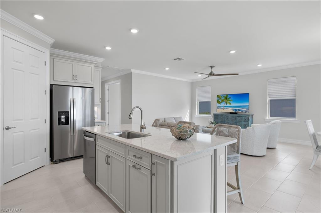 318 Deauville Loop Naples, FL 34114 - Photo 10 of 21 a kitchen with stainless steel appliances granite countertop a sink and a refrigerator